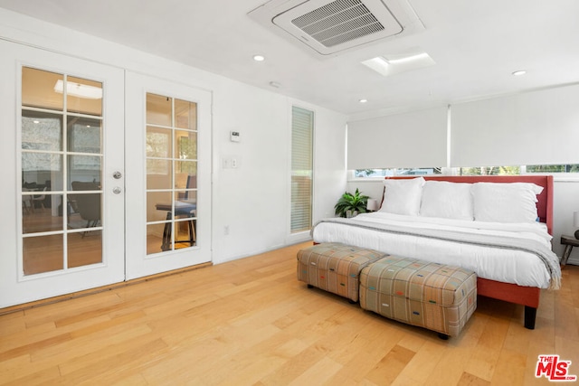 bedroom featuring french doors, light hardwood / wood-style floors, and access to outside