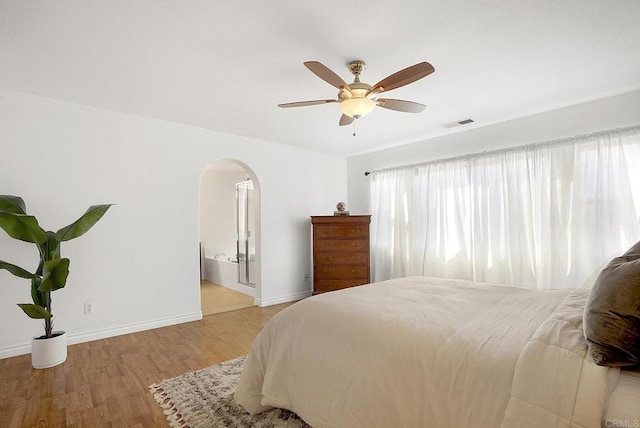 bedroom featuring ensuite bath, light hardwood / wood-style flooring, and ceiling fan