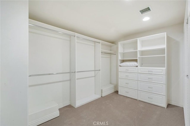 walk in closet featuring light carpet and visible vents