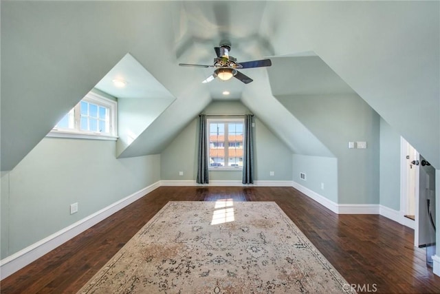 bonus room featuring dark wood-type flooring, lofted ceiling, ceiling fan, and baseboards