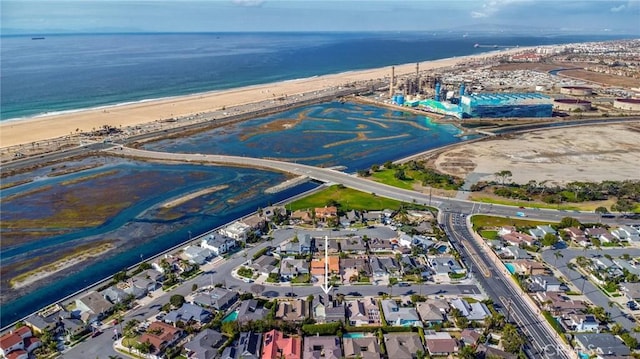 drone / aerial view featuring a residential view, a water view, and a beach view