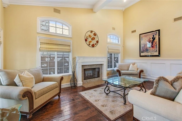 living room featuring visible vents, a high end fireplace, beam ceiling, dark wood finished floors, and crown molding