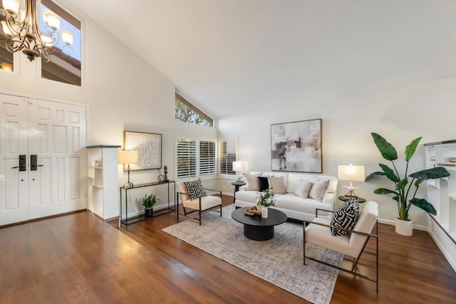 living room with an inviting chandelier, high vaulted ceiling, and dark hardwood / wood-style floors