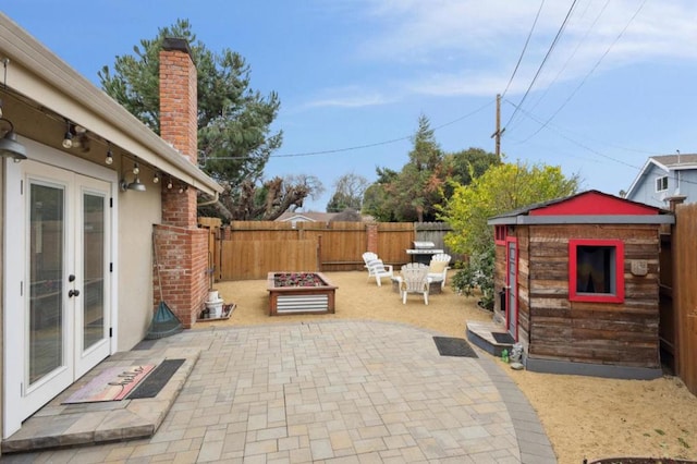 view of patio with french doors and a storage unit