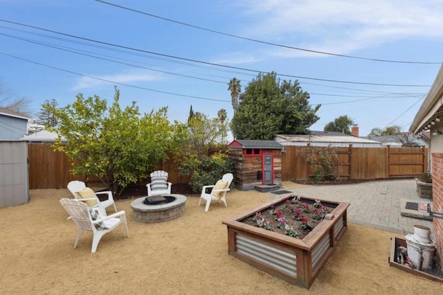 view of patio with a storage shed and an outdoor fire pit