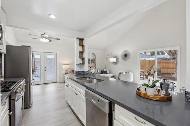 kitchen featuring french doors, lofted ceiling, sink, stainless steel appliances, and white cabinets