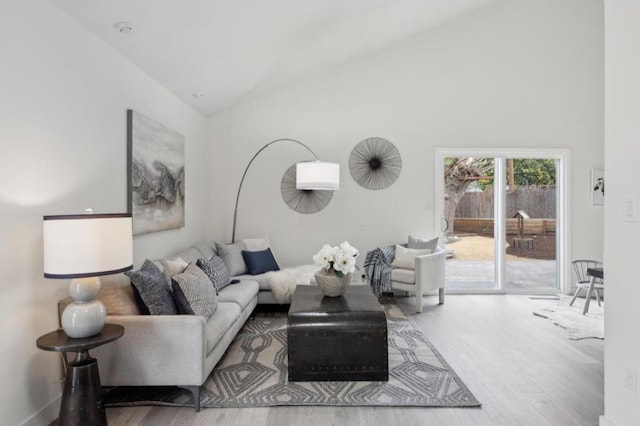 living room with high vaulted ceiling and light hardwood / wood-style floors