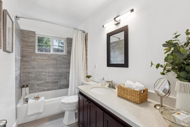 full bathroom featuring vanity, hardwood / wood-style flooring, toilet, and shower / bath combo