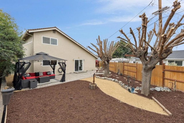 rear view of property featuring a gazebo, an outdoor hangout area, and a patio