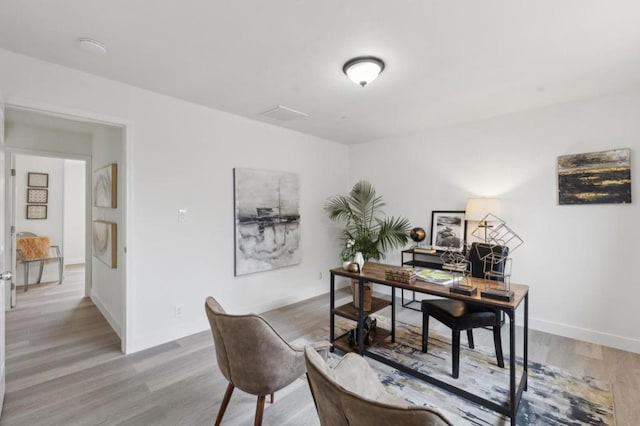 home office with light hardwood / wood-style floors