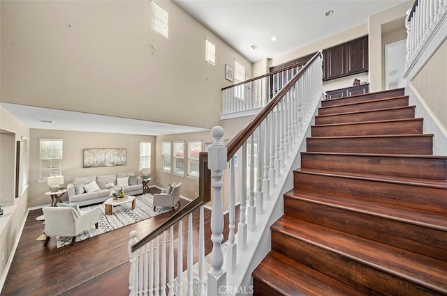 staircase featuring a high ceiling and wood-type flooring