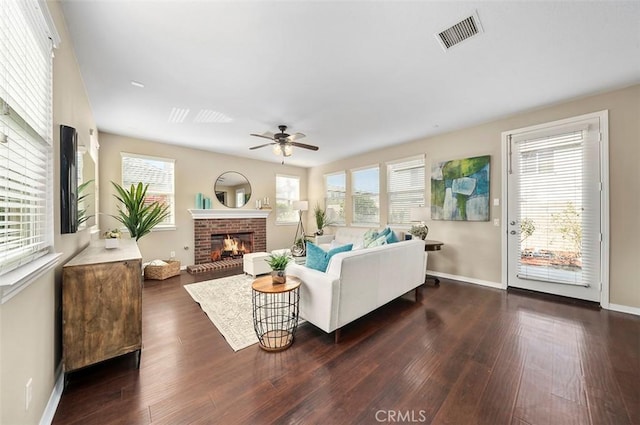 living room featuring ceiling fan, a brick fireplace, and dark hardwood / wood-style flooring