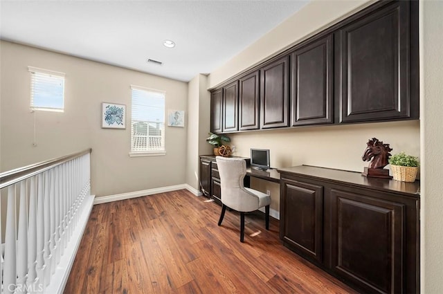 office area featuring dark hardwood / wood-style floors and built in desk