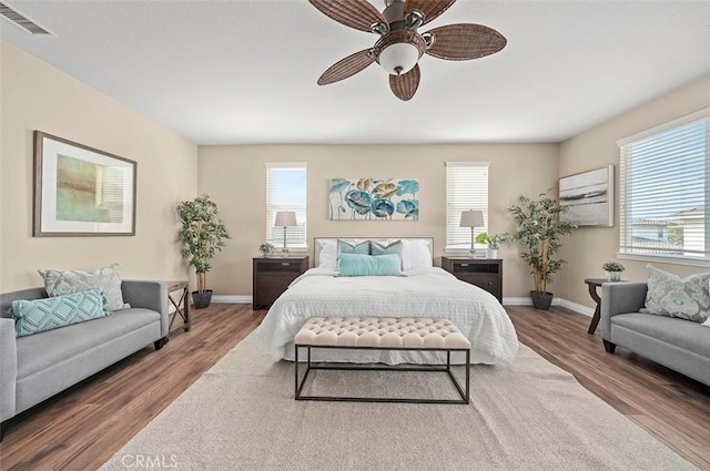 bedroom featuring multiple windows, wood-type flooring, and ceiling fan