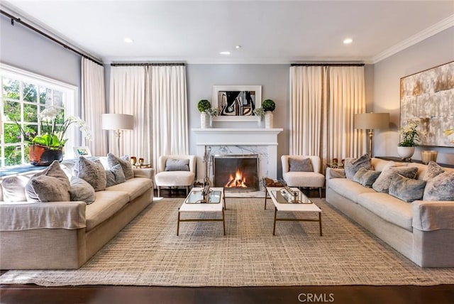 living room featuring ornamental molding and a high end fireplace