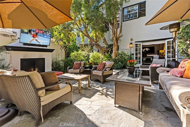 view of patio with an outdoor living space with a fireplace