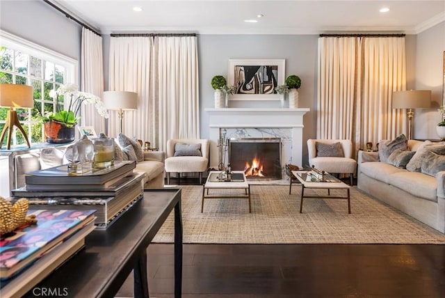 living room featuring crown molding, hardwood / wood-style floors, and a fireplace