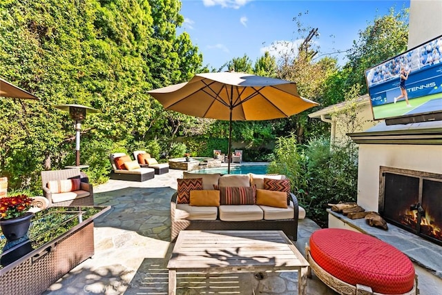 view of patio featuring an outdoor living space with a fireplace