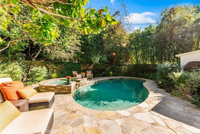 view of pool featuring a patio and an in ground hot tub