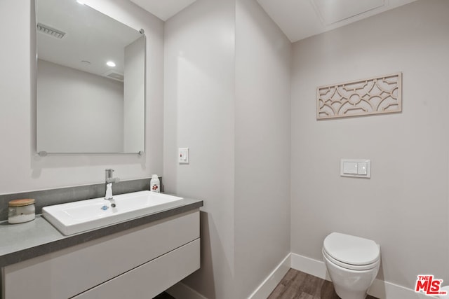 bathroom with vanity, hardwood / wood-style floors, and toilet