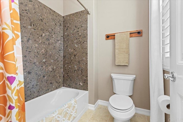 bathroom with baseboards, toilet, shower / tub combo with curtain, and tile patterned flooring