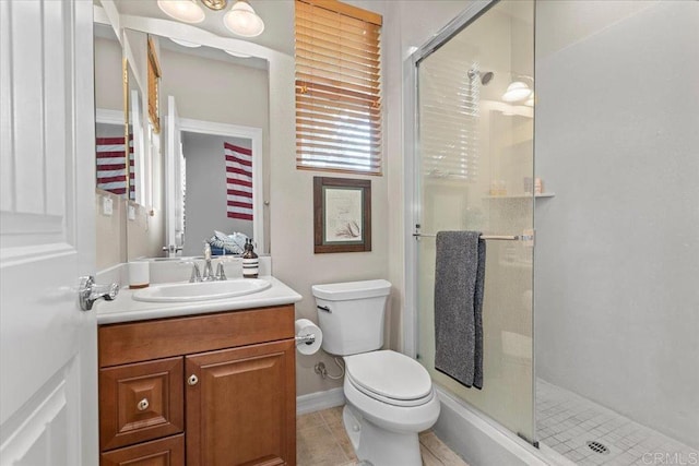 full bath featuring tile patterned flooring, a shower stall, toilet, and vanity