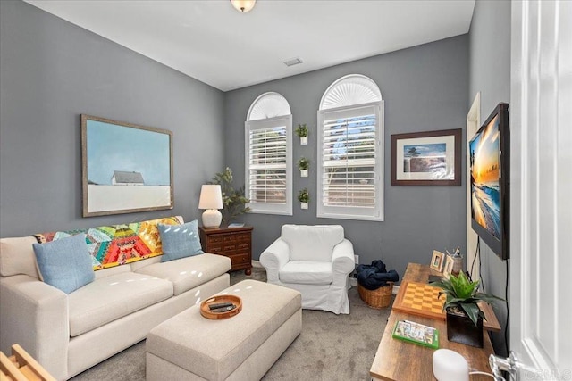 living area featuring visible vents and carpet floors