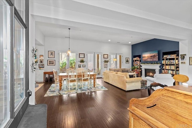 living room with recessed lighting, dark wood-style floors, and a warm lit fireplace