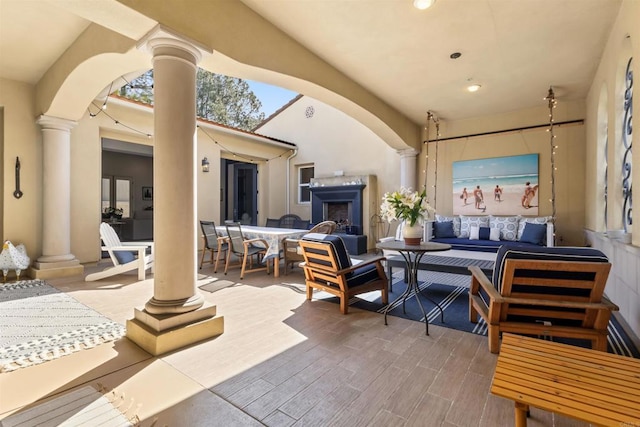 view of patio featuring outdoor dining area and an outdoor living space with a fireplace