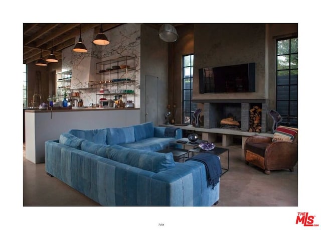 living room with beam ceiling, concrete floors, and a wealth of natural light