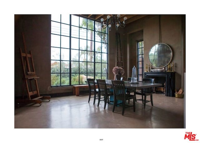 dining space featuring concrete floors and a chandelier