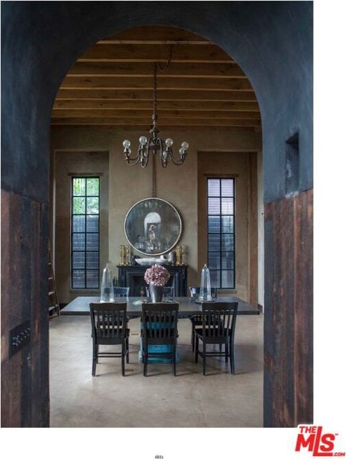 dining area featuring concrete flooring, an inviting chandelier, and beamed ceiling