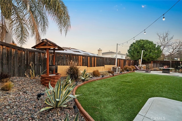 yard at dusk featuring cooling unit and a patio area