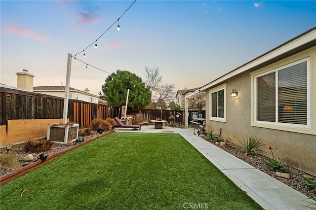 yard at dusk with a patio area and an outdoor fire pit