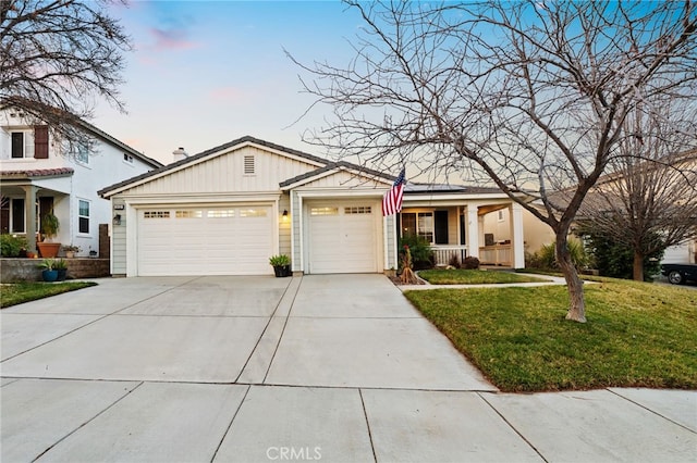 view of front of property featuring a garage, a porch, and a yard