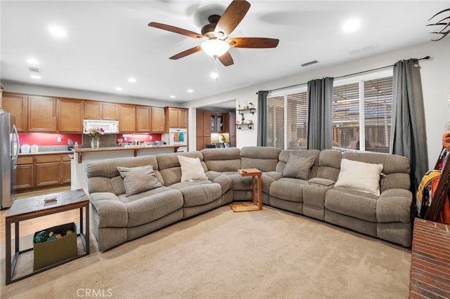 carpeted living room featuring ceiling fan