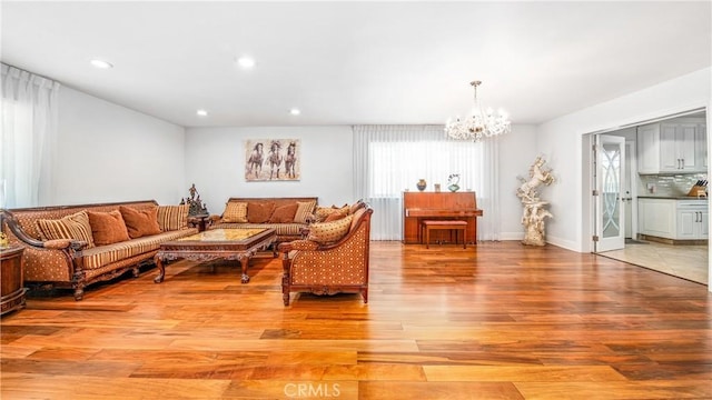 living room featuring an inviting chandelier and light hardwood / wood-style flooring