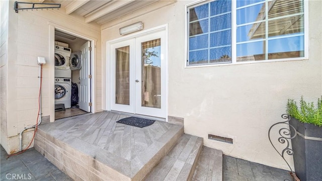 entrance to property featuring french doors and stacked washer / dryer