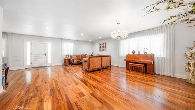 living room with an inviting chandelier and light wood-type flooring