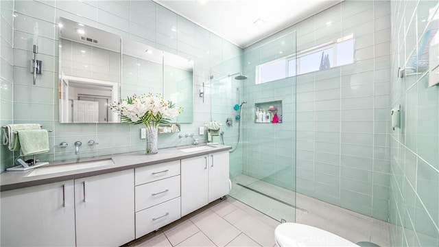 bathroom with vanity, tile patterned flooring, a shower with door, and tile walls