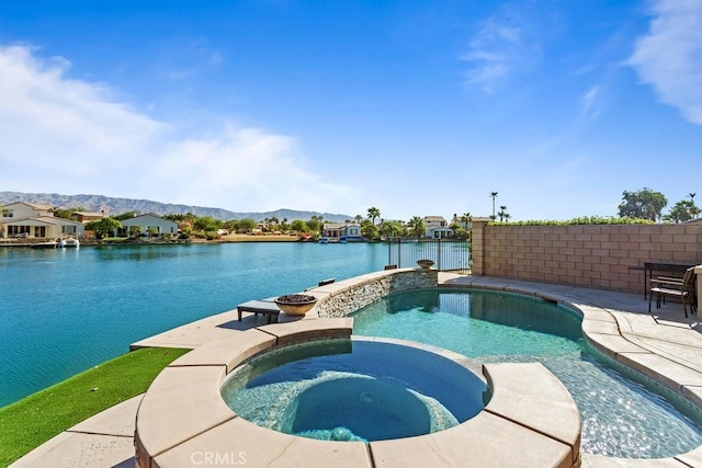 view of swimming pool featuring an in ground hot tub, a patio, and a water and mountain view