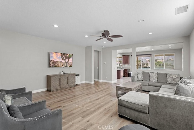 living room featuring ceiling fan and light hardwood / wood-style flooring