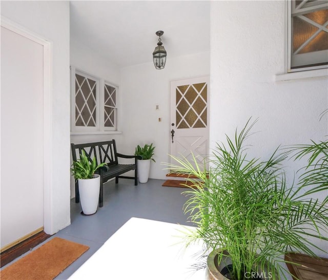 property entrance with stucco siding and covered porch