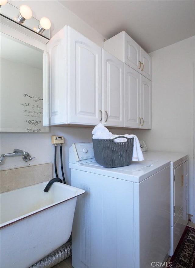 clothes washing area with independent washer and dryer, sink, and cabinets