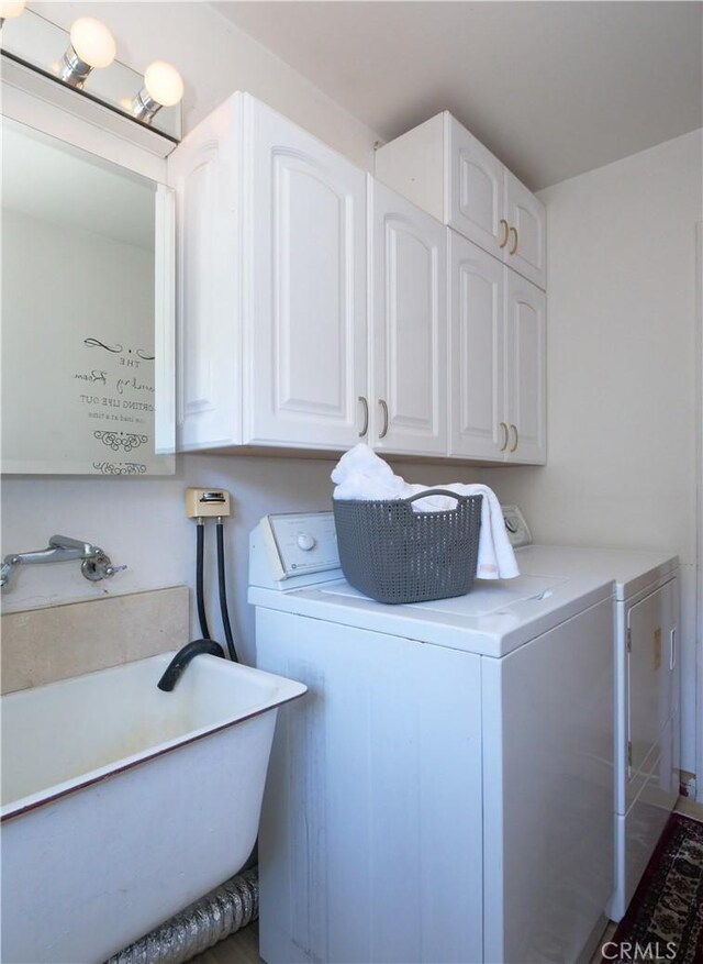 clothes washing area featuring a sink, cabinet space, and washing machine and dryer