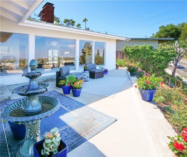 view of patio with an outdoor living space and fence