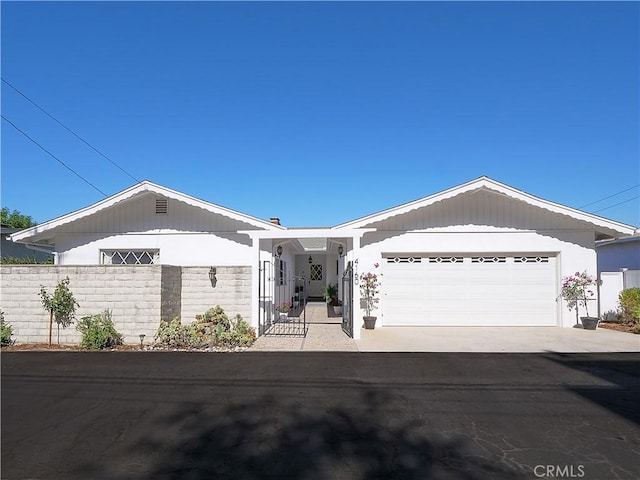 ranch-style home featuring driveway, a garage, and fence