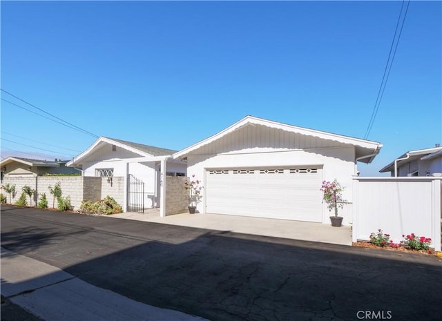 single story home with fence, a gate, a garage, and concrete driveway