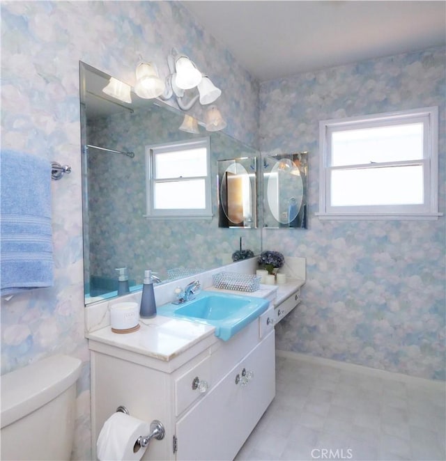 full bathroom featuring wallpapered walls, vanity, and toilet