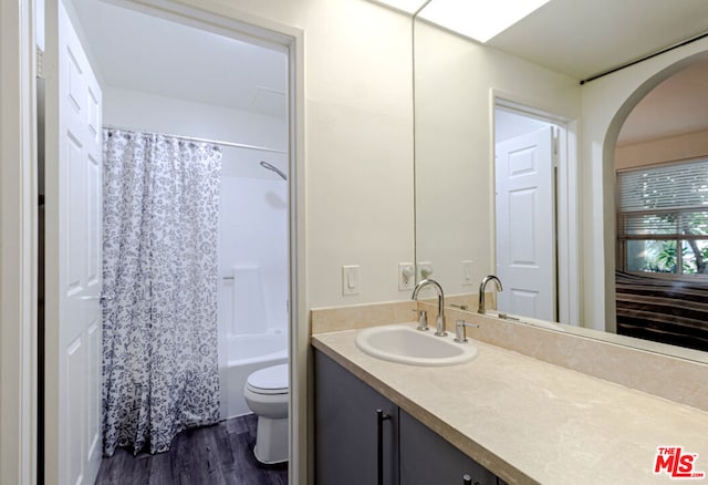 full bathroom featuring shower / tub combo with curtain, wood-type flooring, toilet, and vanity